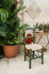 Old medieval clay pot with ivy, chair over stone wall. Traditional European, Greek architecture. Summer travel