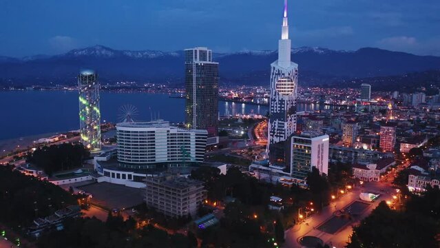 Scenic view from drone of seaside area of Batumi overlooking buildings of modern hotels and high-rise tower of Technological University on spring twilight, Georgia