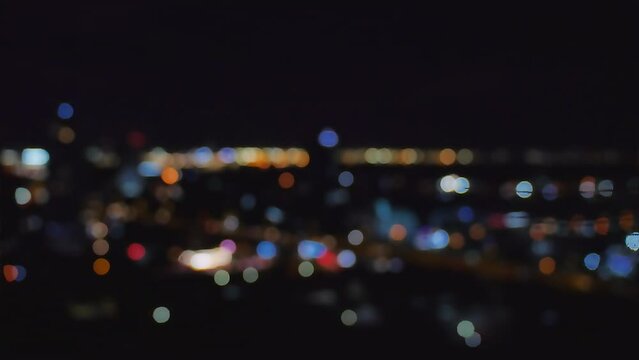 Footage video, defocused blurry motion colorful bokeh of city night light traffic, abstract dark background of cityscape, element template, overlay effect