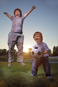 child play soccer (football) player. Boy kick on ball on green grass.