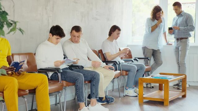 Portrait of a focused European man sitting in a chair in the lobby waiting. . High quality 4k footage