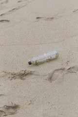 Plastic trash at the sandy beach. Plastic pollution concept. Single-use plastic is a human addiction that is destroying our planet and impacts our waters, sea life and humans.