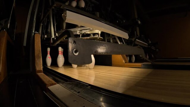 Pinsetter places the bowling pins at a bowling alley - slow motion behind the scenes