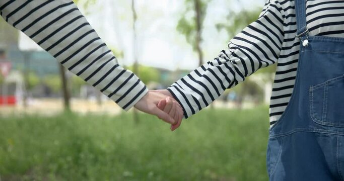 커플룩을 입고 손을 잡은 모습 클로즈업 