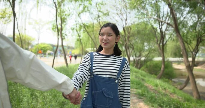 아빠 손을 잡고 밝은 표정으로 웃는 딸 