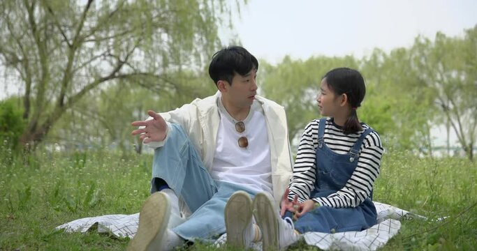 피크닉 담요에 앉아 즐겁게 대화하는 아빠와 아이 
