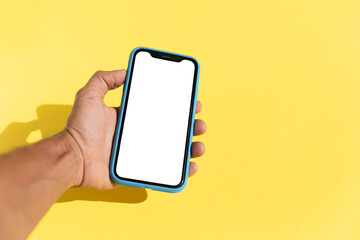 Black male hand holding a smart phone isolated blank screen yellow background