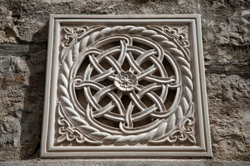 Fototapeta na wymiar Kotor, Montenegro - Detail of carved stone decoration on an ancient house wall