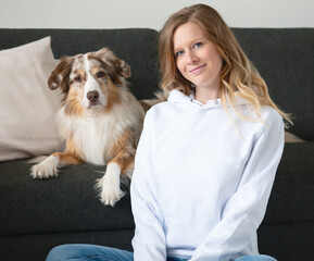 Frau mit Hund Australian Shepherd weißer Pullover Hoodie Jeans Mockup Indoor Sofa Zuhause Kissen...
