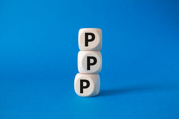 PPP private public partnership symbol. Wooden cubes with words PPP. Beautiful blue background. Business and PPP concept. Copy space.