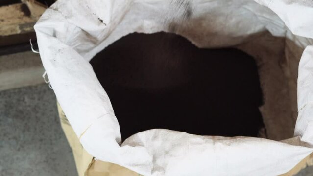 indian factory for tea production automate machine separete different size of leaf, sieving machinery close up filling a bag established shot 