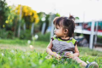 child sitting on the grass in the evening