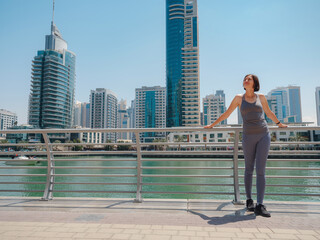 Fototapeta na wymiar City Running - asian woman runner , Dubai marina urban scene in background. Female athlete, fitness athlete jogging training, living healthy lifestyle.