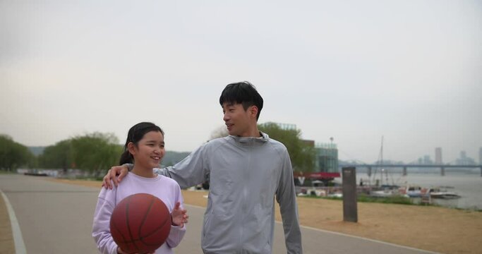 농구공을 든 딸과 어깨동무하는 아빠 