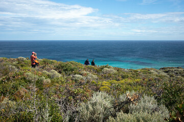Fototapeta na wymiar a man walking into the bushes od western Australia with the turquoise Indian ocean.