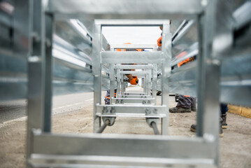 Installation of median crash barriers on highway. Metal road fencing of barrier type on freeway. Road guard rails. Safety barrier with a red and white striped sign. Protect vehicles from accidents.