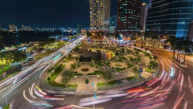Timelapse view of Tran Hung Dao roundabout with heavy traffic near Bach Dang waterbus station port and Saigon river at sunset in Ho Chi Minh city, Vietnam