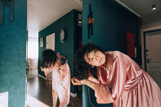 Woman blow drying hair at home