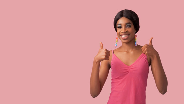 Like gesture. Positive feedback. Perfect choice. Satisfied excited cheerful smiling woman recommending with approval thumbs up isolated on pink empty space advertising background.