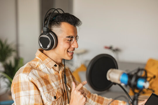 Man podcasting using headphones at home
