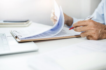 Asian businessman reviewing document reports at office with computer laptop, legal expert,...