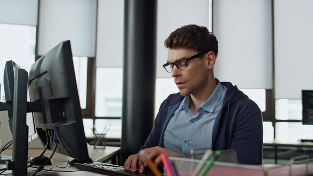 Thoughtful office manager typing computer. Focused software engineer programming
