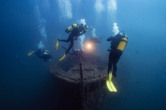 Men and women examining El Naranjito sunken ship undersea