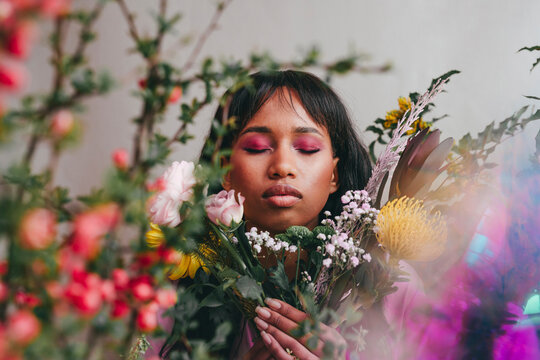 Woman with eyes closed amidst flowers