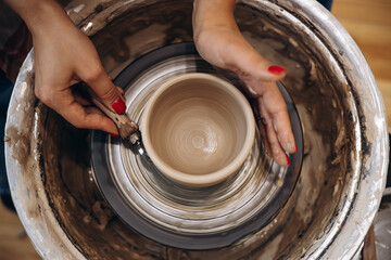 Woman working on pottery wheel creating a bowl