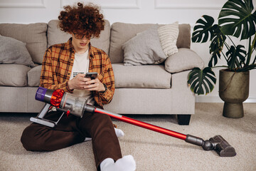 Man doing house work with wireless vacuum cleaner