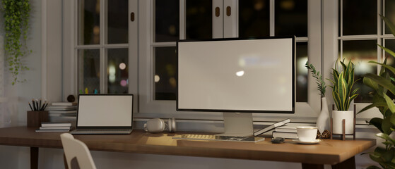 Fototapeta na wymiar Comfortable and minimalist home workspace at night with PC computer and laptop mockup