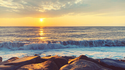 Seascape, sea landscape with waves and rocky coast at sunny sunset in the evening