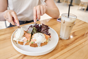 restaurant dish Brioche with poached egg with salmon and avocado. Delicious bread with greens