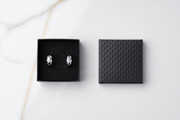 Golden earrings and jewelry box on table close up