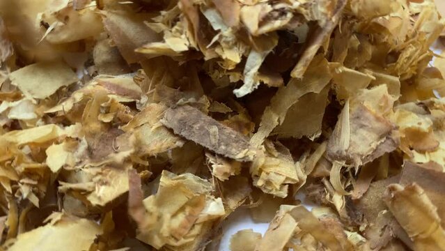 Turning okonomiyaki or Katsuobushi. Katsuobushi is a kind of very thin bonito fish flakes. The color is brown, the shape is thin and like paper. Selective focus footage