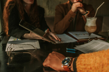 Close up shot of male and female business people working on tablet