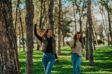 Two girls dancing and singing while hanging out in the park