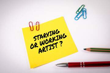 Starving or working artist. Yellow sticky note with text on a white background