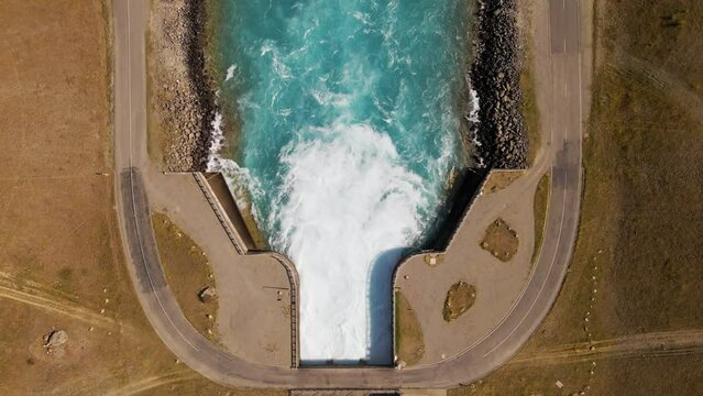 Static drone view of water barrage with turquoise water entering canal