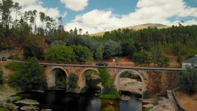River with a Car in a Stone Bridge in a Summer Dav