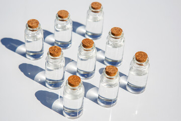 Small glass bottles with cork pattern on a white background, medicine care beauty farmacy concept