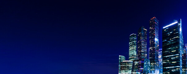 Night business center banner background with Copy space. Night tech office skyscrapers. Business, economy, technology, internet concept.