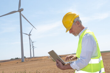 Engineer using laptop for wind turbine inspection