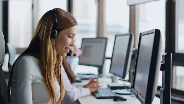 Smiling operator typing computer in data center. Joyful woman assistant at work.