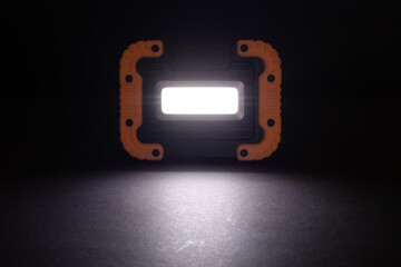 Closeup pocket LED flashlight on dark background.