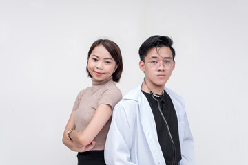 Portrait of professional man, doctor, physician, and woman posing side by side looking fierce and serious. Isolated on a red background.