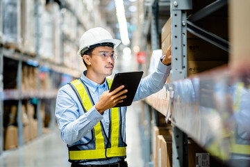 Warehouse Worker using digital tablets to check the stock inventory in large warehouses, a Smart warehouse management system, supply chain and logistic network technology concept.