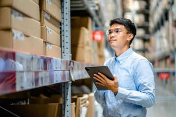 Businessman or supervisor uses a digital tablet to check the stock inventory in large warehouses, a Smart warehouse management system, supply chain and logistic network technology concept..