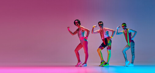 Three men in colorful retro sportswear training, doing aerobics exercises against gradient blue pink background. Concept of sportive and active lifestyle, humor, retro style. Banner. Copy space for ad