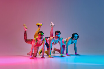 Three stylish men in colorful vintage sportswear doing legs exercises against gradient blue pink studio background in neon light. Concept of sportive and active lifestyle, humor, retro style. Ad